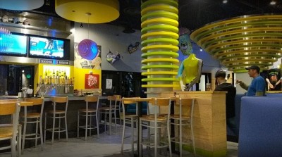 Interior space of bar area of Mellow Mushroom with bright decor