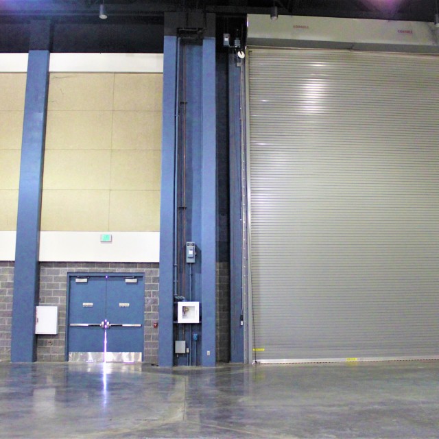 Roll up door in Exhibit Hall B with emergency exit door located on left side