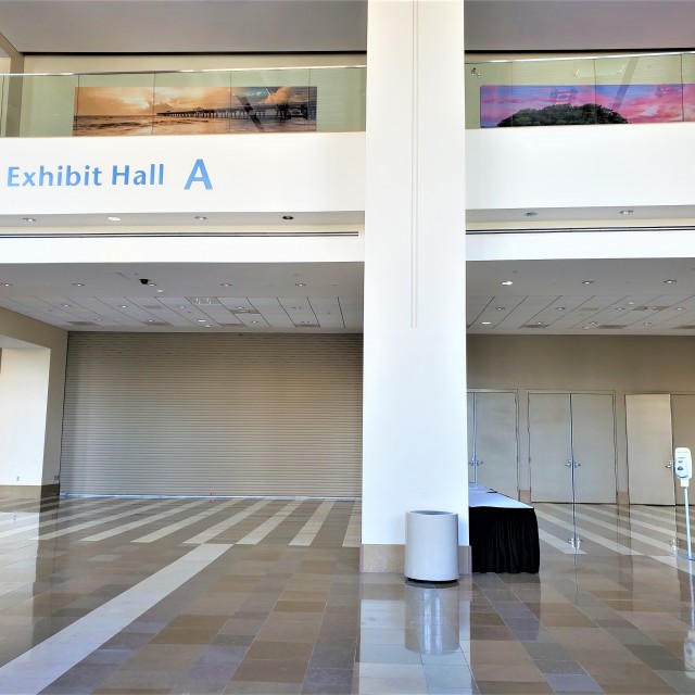 Exhibit Hall A entrance showcasing roll up and three sets of doors with marble flooring